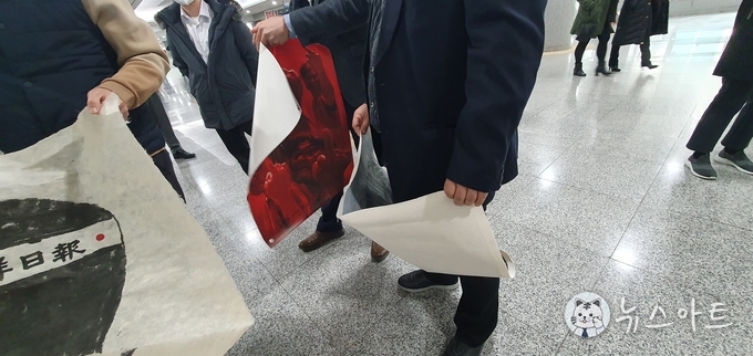 사무처 직원들이 통에 담아 옮겨야 하는 작품을 손에 들고 있다. 장갑도 안 끼고. 이리 저리 흔든다.